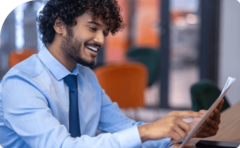 Smiling man reviewing documents at desk